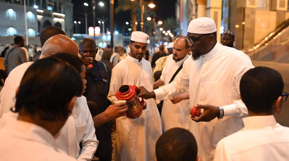 الموظف السعودي عامر عبدالله يوزع أكواب الشاي على الحجاج قرب المسجد الحرام في مكة المكرمة - ا ف ب