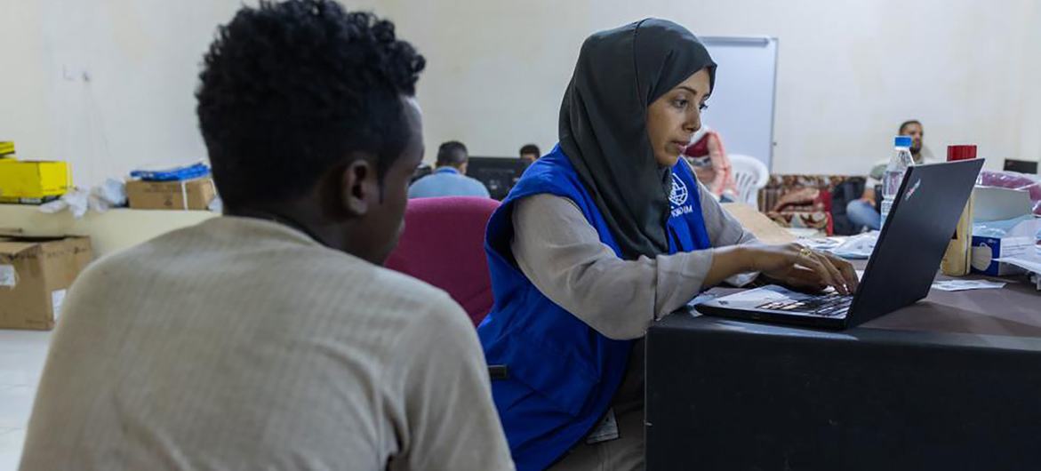 © IOM Yemen/Elham Al-Oqabi إحدى موظفات المنظمة الدولية للهجرة تسجل مهاجرا إثيوبياً في مأرب باليمن، قبل السفر إلى أديس أبابا.